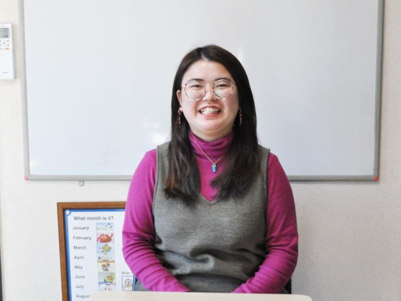 福岡市にある金舜華の韓国語教室の古賀先生が教室内のホワイトボードの前に座っている時に撮った写真。